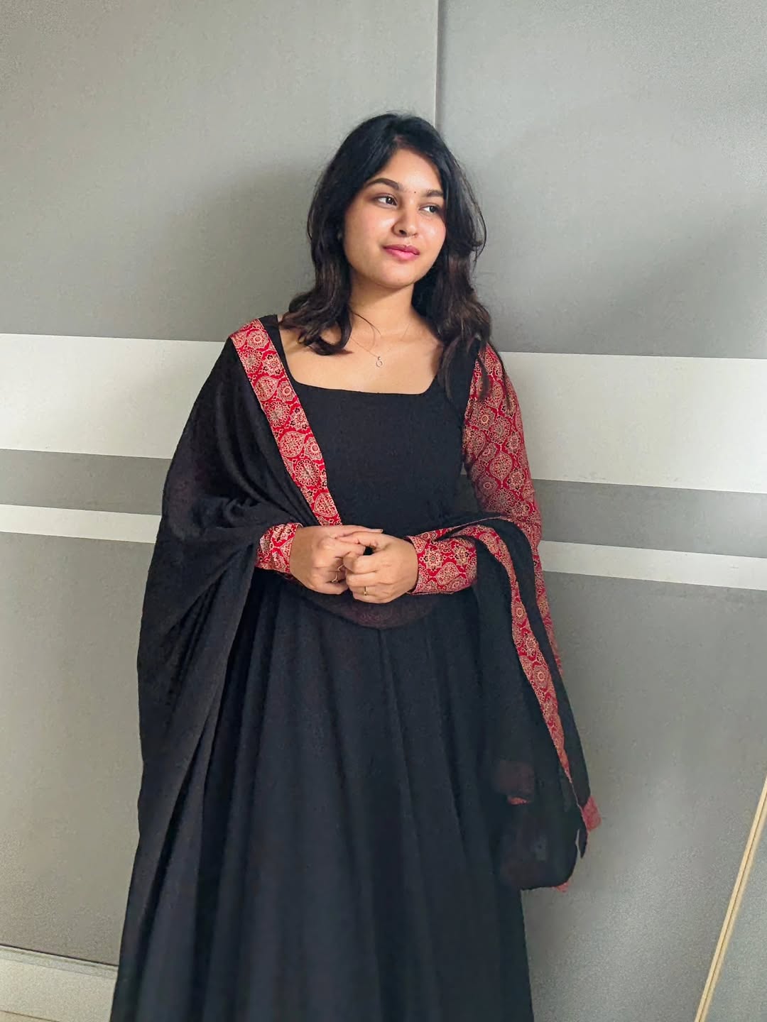 stunning portrait of a young woman exuding grace and poise in a traditional black Anarkali outfit.(JORJET)