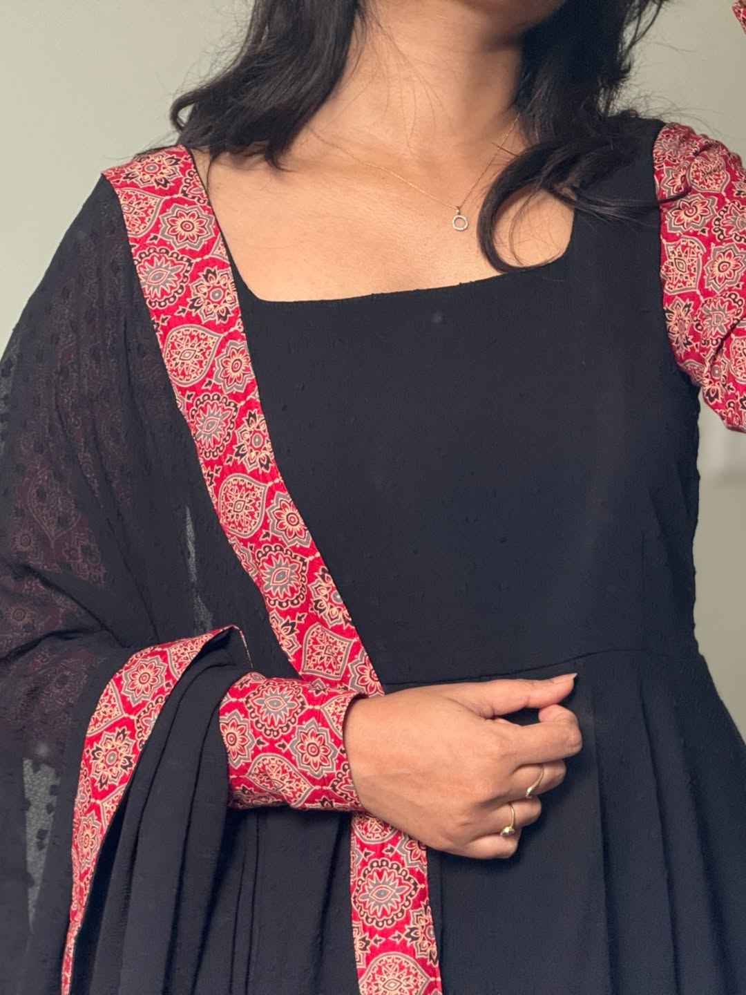 stunning portrait of a young woman exuding grace and poise in a traditional black Anarkali outfit.(JORJET)