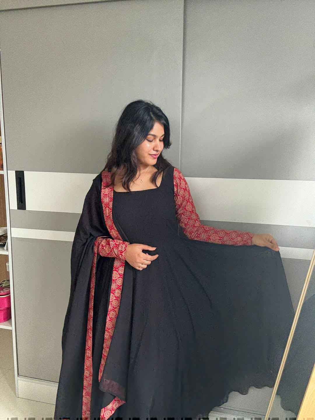 stunning portrait of a young woman exuding grace and poise in a traditional black Anarkali outfit.(JORJET)